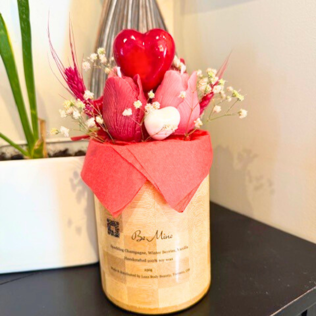 A wooden vase filled with candles shaped like pink and red roses. decorated with big red heart in the middle and botanical flora with many other small hearts