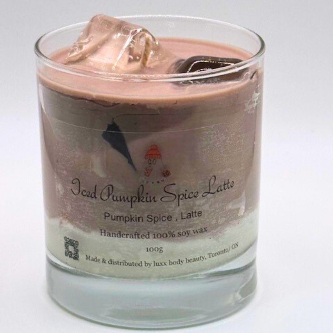 A single-wick candle in a clear jar, designed to resemble an iced latte, with a white layer at the bottom, a rich brown coffee-colored wax, and a clear ice cube detail on top.