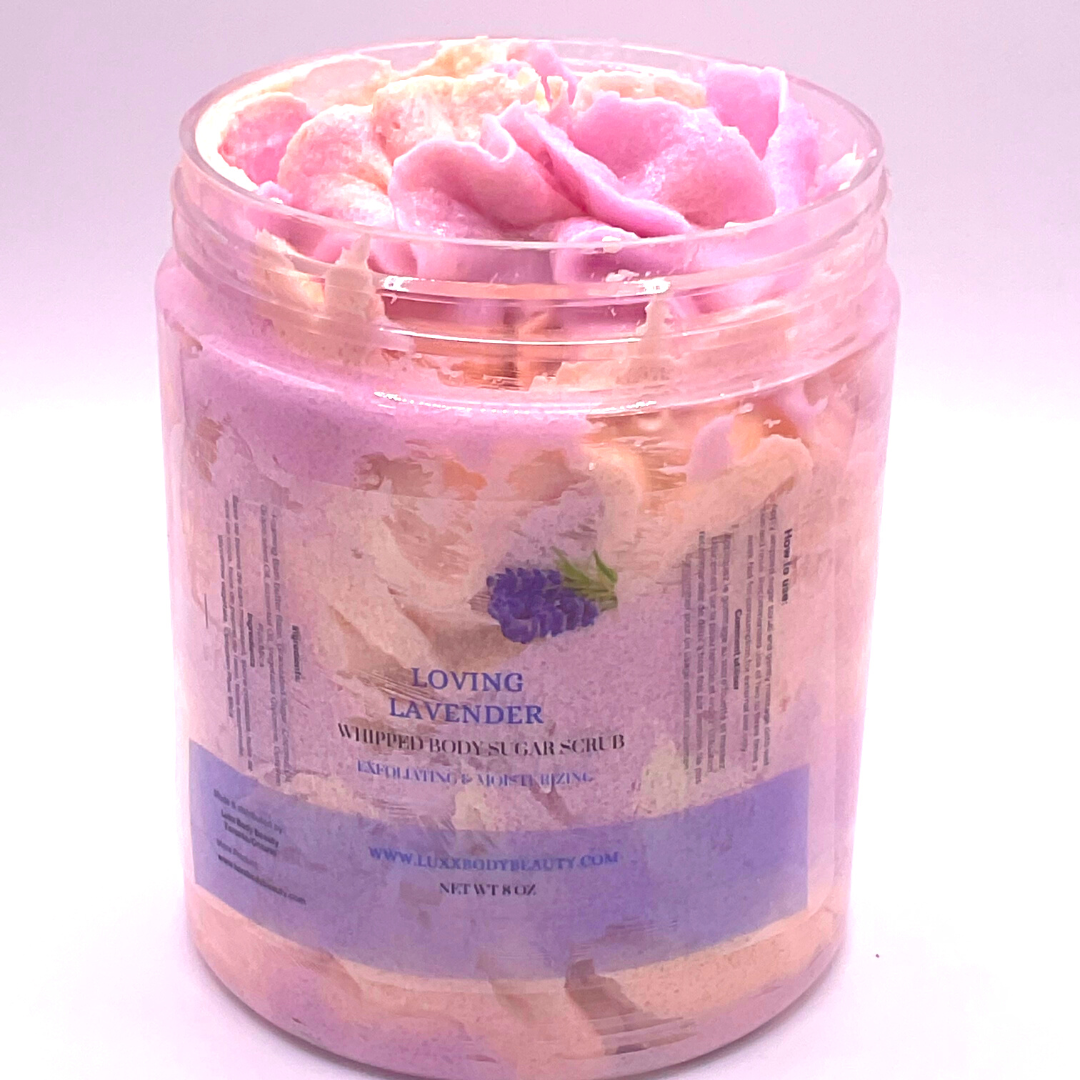 A whipped foamy sugar scrub in purple and yellow colors, piped into a clear jar.