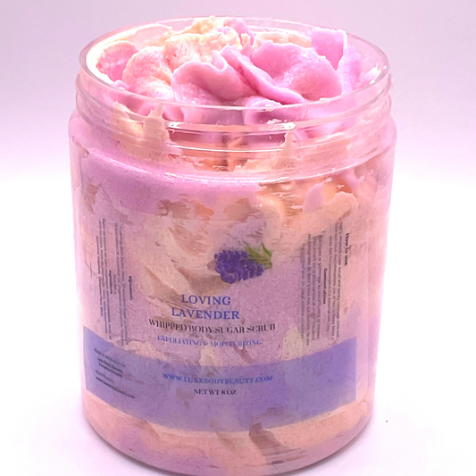 A whipped foamy sugar scrub in purple and yellow colors, piped into a clear jar.
