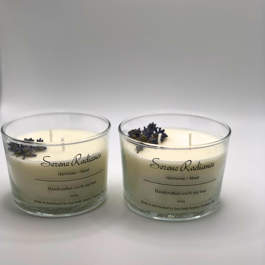 A single-wick white candle in a clear jar, topped with a dried Lavender floral decoration.