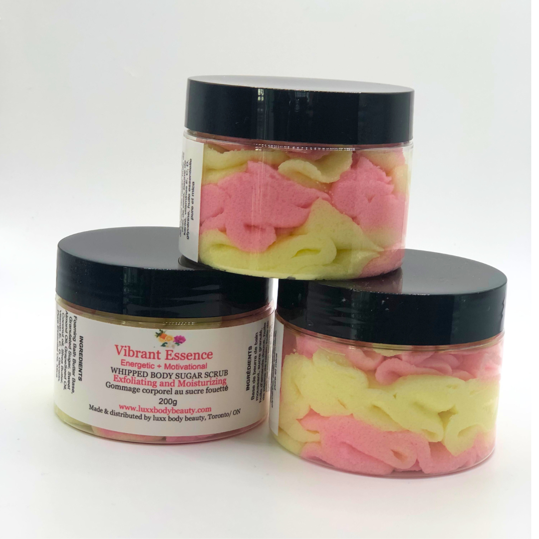 A whipped foamy sugar scrub in a clear jar is made of pink and yellow layers.