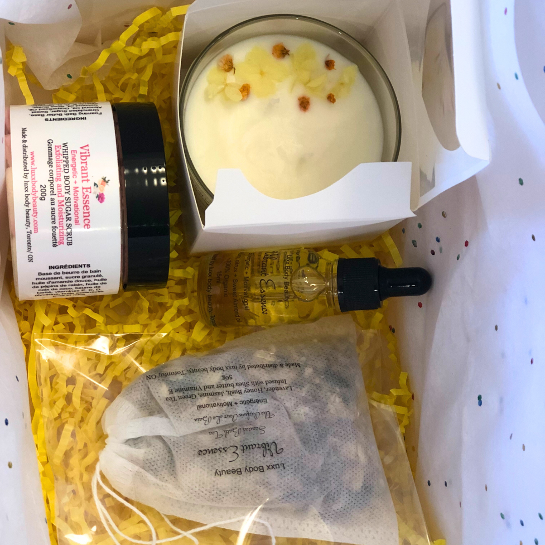 A home spa day set featuring a candle, body oil bottle, bath tea, and sugar scrub jar.