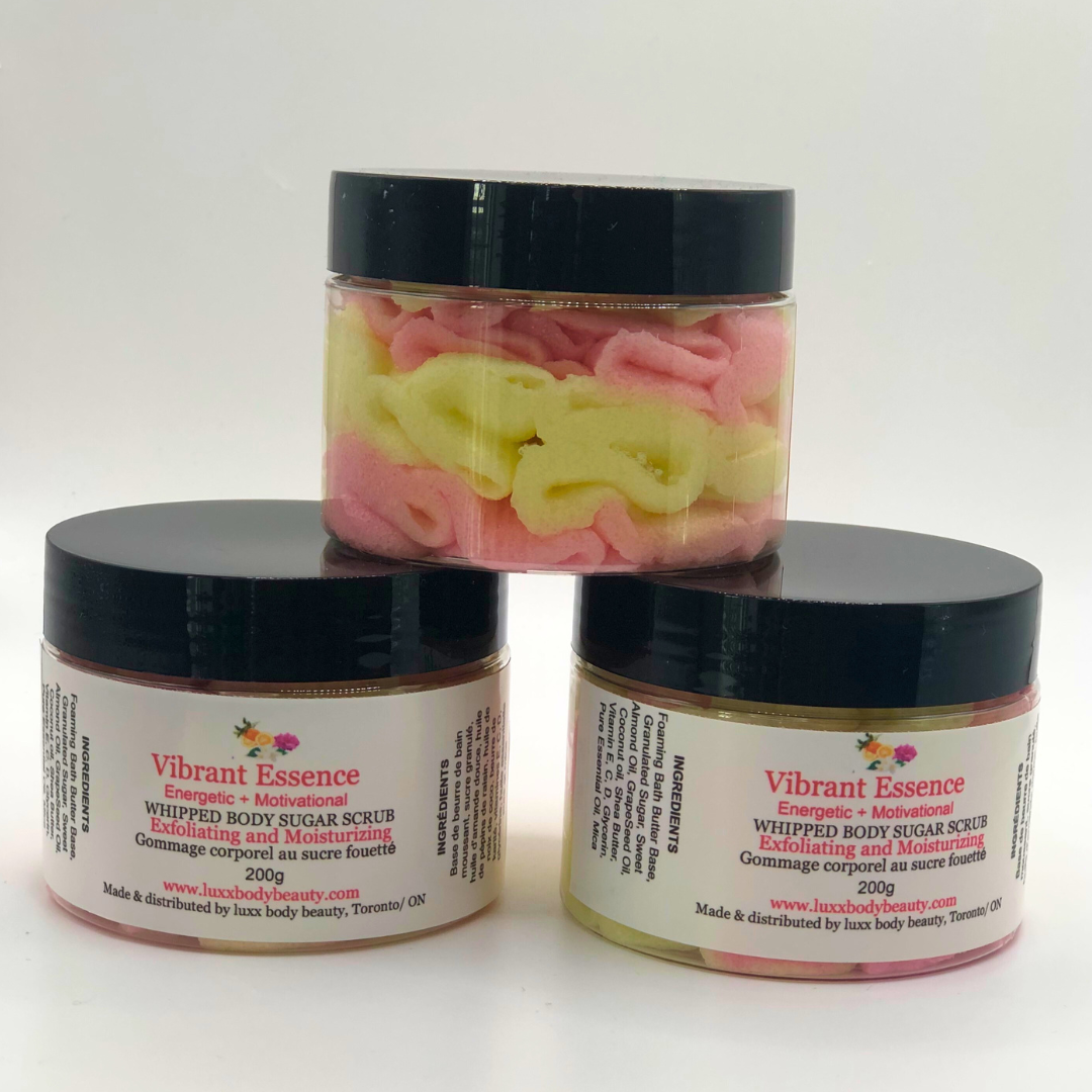 A whipped foamy sugar scrub in a clear jar is made of pink and yellow layers.