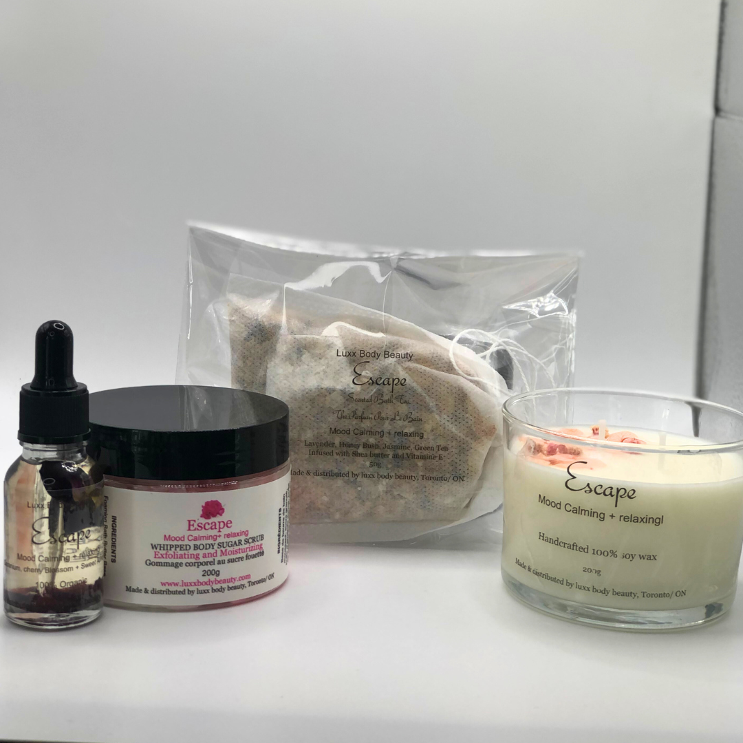 A home spa day set featuring a candle, body oil bottle, bath tea, and sugar scrub jar.