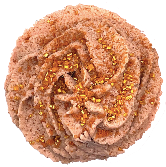 A light brown cupcake-shaped bath bomb topped with light brown bubble bath icing, topped with golden pearls.