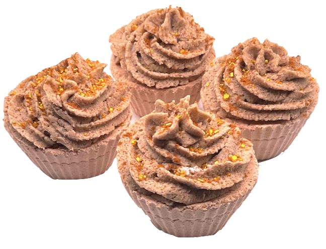 A light brown cupcake-shaped bath bomb topped with light brown bubble bath icing, topped with golden pearls.