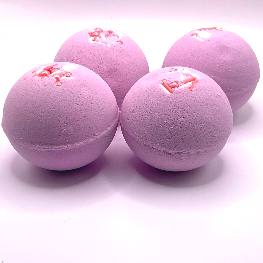 A purple round bath bomb topped with white and pink pearls.