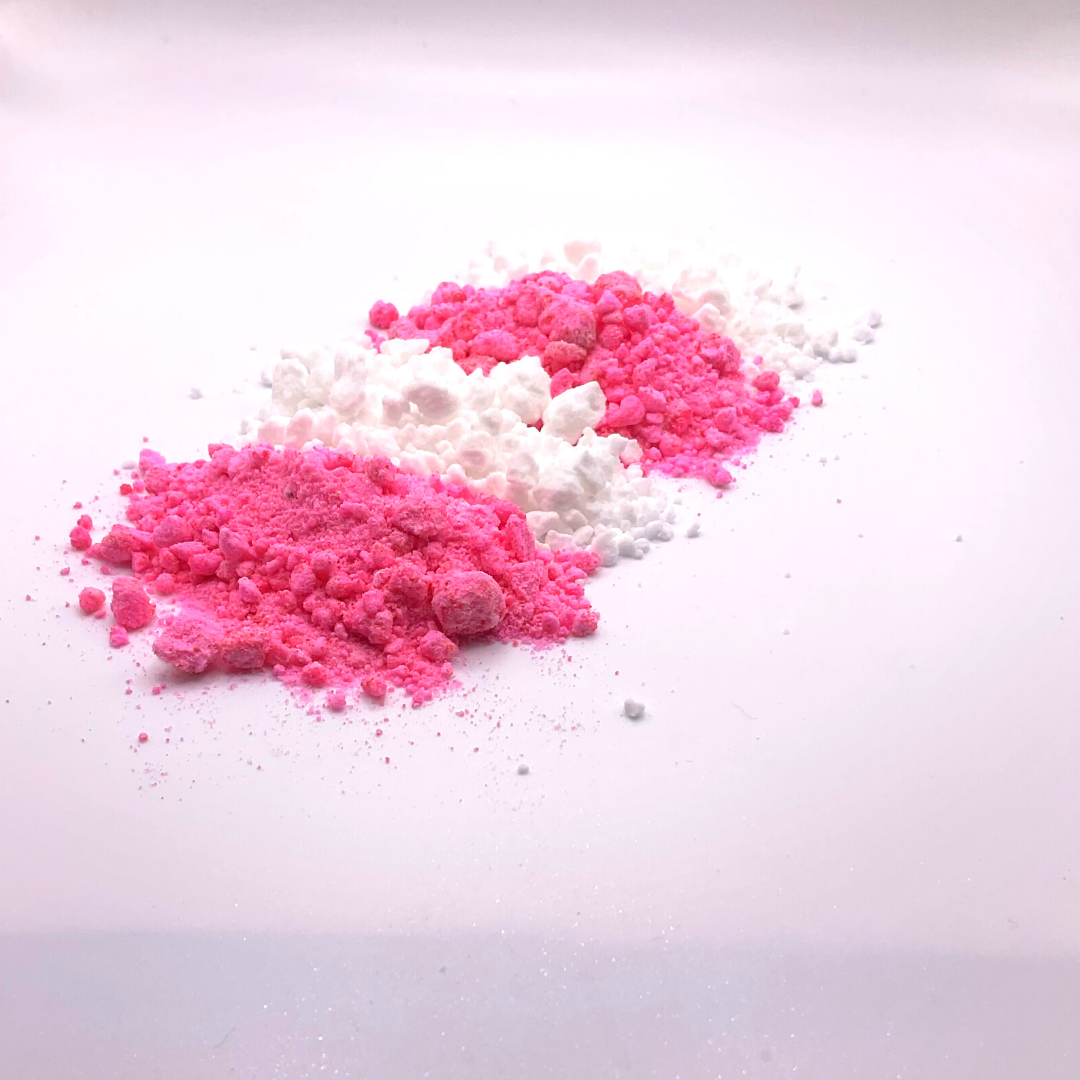 A white and pink bath bomb crumble in a striped pattern.