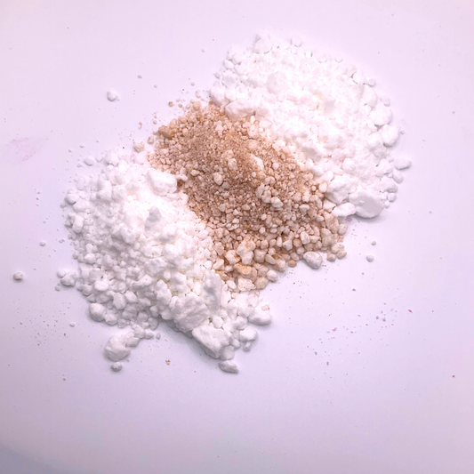 A white and light brown bath bomb crumble in a striped pattern.