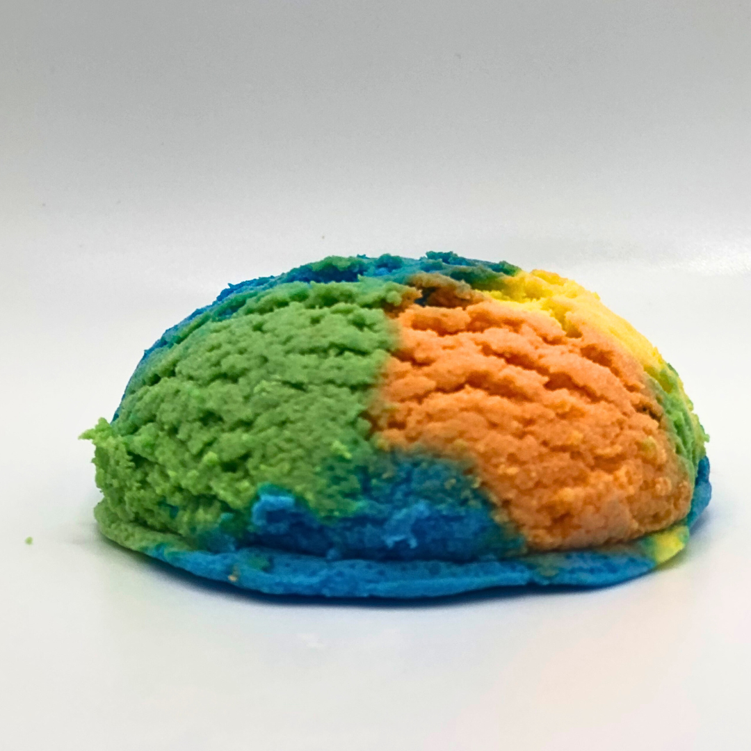 An ice cream scoop-shaped bubble bath in yellow, orange, green, and blue.