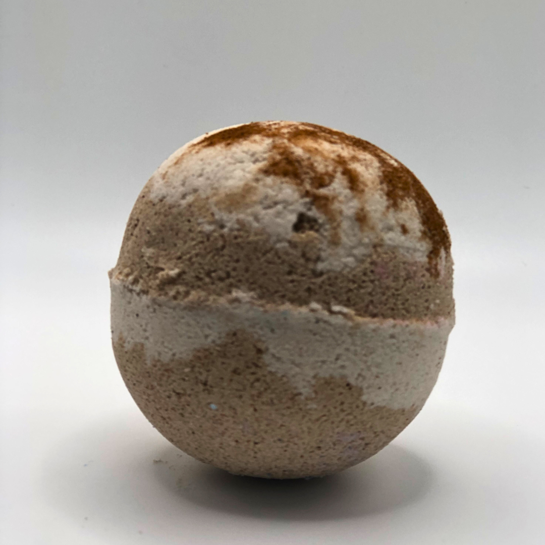 A round bath bomb with chocolate and off-white colors.