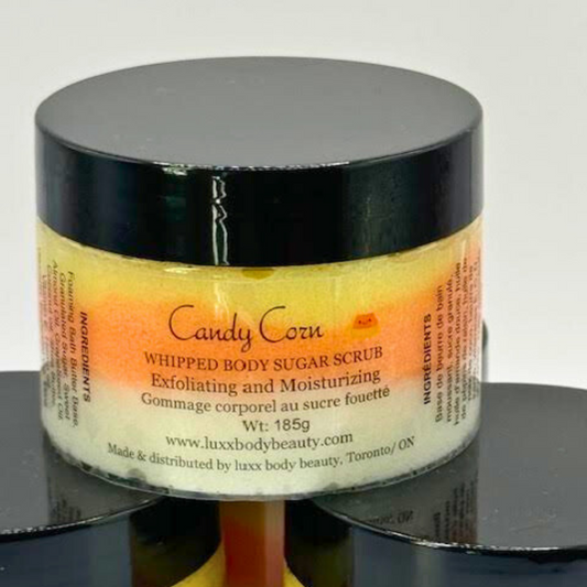 A whipped sugar scrub in a clear jar is made of white, orange, and yellow layers, the same as candy corn.